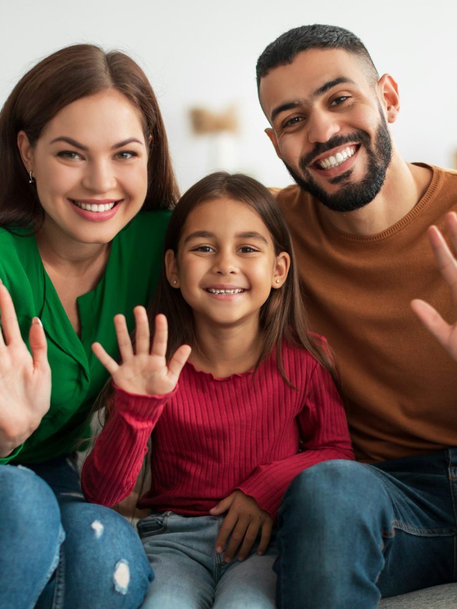 Portrait of happy family waving hands at camera